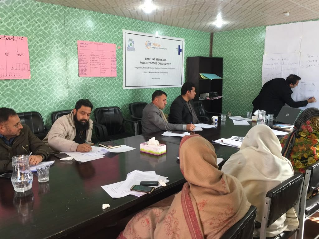 Facilitated training and working session with participants around a table, analysis recorded on flipcharts and a facilitator at the whiteboard