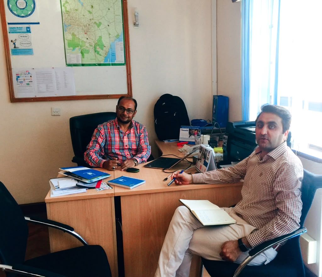Key informant interview under way in a country office, with programme documents and a wall map visible